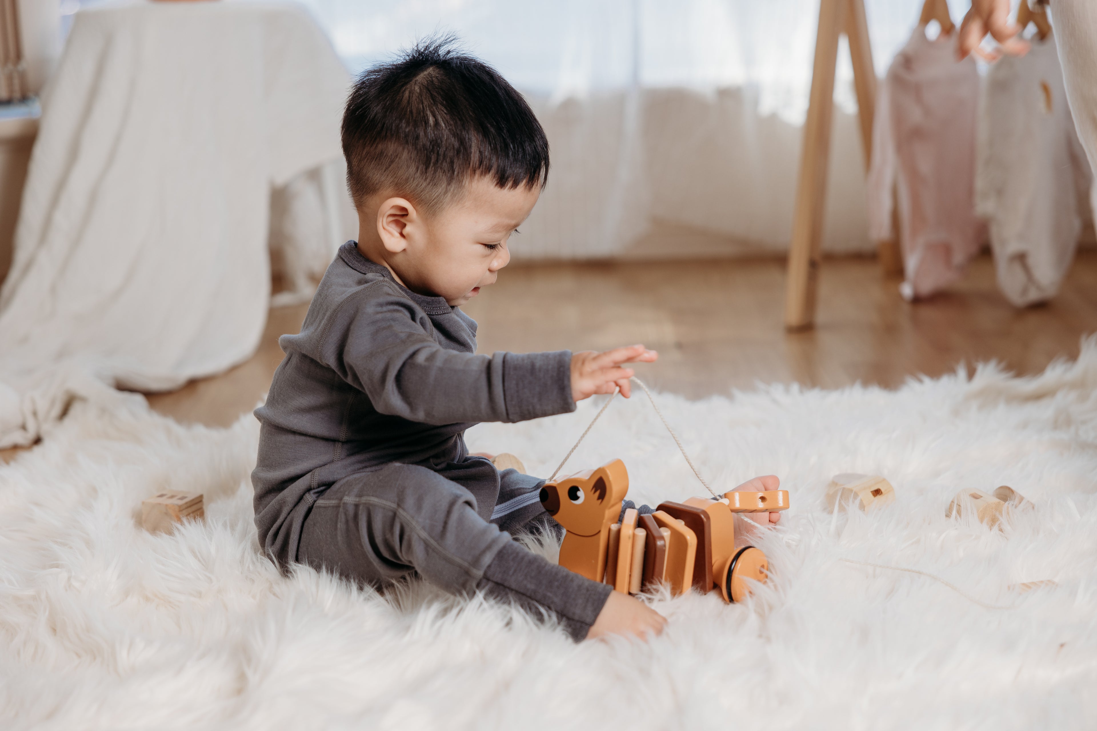 Child playing with a toy on a fluffy white rug
